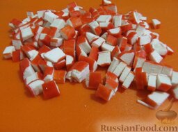Салат из пекинской капусты и крабовых палочек "Ромашка": Крабовые палочки нарежьте мелкими кубиками.