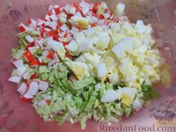 Салат из пекинской капусты и крабовых палочек "Ромашка": В миске смешайте капусту, крабовые палочки и резаные кубиками яйца.