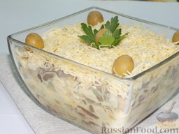 Салат с опятами, фасолью и оливками: Выложить в салатник. Сверху выложить вторую часть натёртого сыра. Украсить салат.
