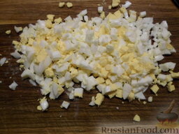 Салат с маслинами и рисом: Нарезаем вареные яйца квадратами.