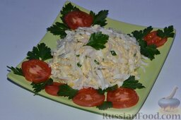Салат из кальмаров с сыром: Выкладываю готовый салат в салатницу горкой, украшаю его листьями свежей петрушки и свежим помидором, нарезанным кружочками.