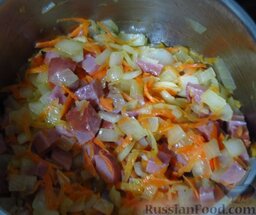 Солянка с фасолью: Потом выложите в кастрюлю колбасу и чеснок, готовьте пару минут, иногда помешивая.