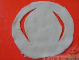 Пирожки с колбасой и сыром (из песочно-кефирного теста): Тесто разделите на 3 части, возьмите одну часть, раскатайте до толщины 0,5 мм, вырежьте из теста стаканом круги. Потом каждый круг еще немного раскатайте скалкой. С двух сторон внутри кружочка сделайте надрезы как на картинке.