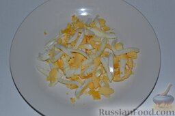 Салат из крабовых палочек и кальмаров: Отваренные яйца нарезаем соломкой.