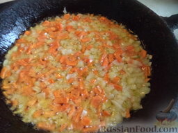 Быстрая солянка с копченостями и картофелем: Разогреть сковороду, налить растительное масло. Добавить лук и морковь. Тушить на среднем огне, помешивая, 2-3 минуты.
