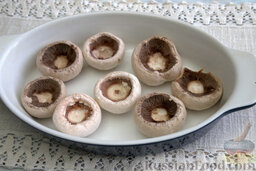 Шампиньоны, фаршированные моцареллой: Выкладываем подготовленные шапочки грибов на форму, предварительно обработанную растительным маслом.