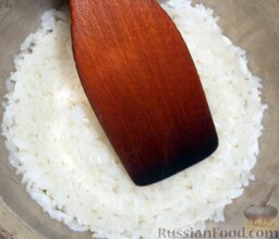 Роллы "Калифорния" с кунжутом: Вылить заправку в рис. Аккуратно перемешать деревянной лопаткой. Теперь оставить рис остывать.