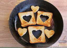 Романтический завтрак: На разогретую сковороду уложить рамки и сердечки из хлеба масляной стороной. Обжарить до приятного румяного цвета, перевернуть. Так как сковорода уже станет масляной, вторую сторону хлеба смазывать нет необходимости.