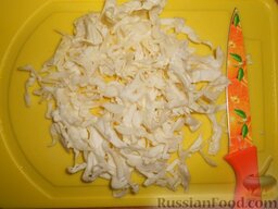 Солянка из свежей капусты с рисом и сосисками: Вымыть, разрезать пополам и нашинковать капусту.