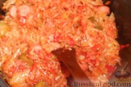 Солянка из свежей капусты с рисом и сосисками: Следом - томатную пасту и специи. Перемешать.