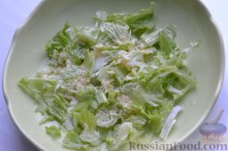 Салат "Цезарь" с курицей: Вторую часть листьев салата нарываем руками. Можно вместо салата использовать пекинскую капусту. Поливаем листья салата или пекинской капусты частью соуса.