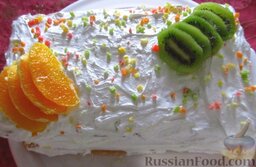 Торт "Тропиканка": Смажьте торт белковым кремом и украсьте фруктами и цукатами, но это уже по желанию.