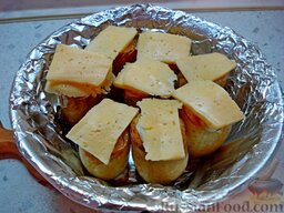 Картофель фаршированный: Вновь достать блюдо из печи. Положить на запекшиеся яйца кусочки сыра.