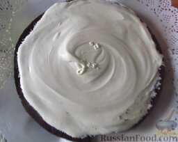Торт "Бисквит в шоколадной короне": Один корж выложите на блюдо, смажьте половиной сливок.