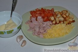 Вкусный салат с ветчиной, сыром, помидорами и сухариками: Готовлю заправку для салата. Для этого натираю чеснок на мелкой тёрке и добавляю его в майонез.