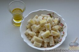 Вкусный салат с ветчиной, сыром, помидорами и сухариками: Сбрызгиваю нарезанные кусочки батона оливковым маслом.