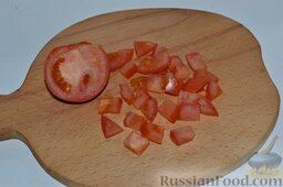Вкусный салат с ветчиной, сыром, помидорами и сухариками: Вымытые помидоры разрезаю пополам, нарезаю колечками. Затем колечки нарезаю кубиками.