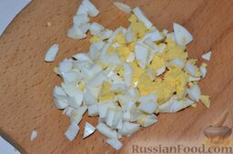 Праздничный салат с ветчиной и болгарским перцем: Куриные яйца вымываем, отвариваем вкрутую. Остудив и очистив яйца, измельчаем их. Смешиваем нарезанные яйца с нарезанными овощами.