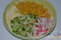 Салат из крабовых палочек: Нарезанный соломкой огурец, высыпаю в миску с салатом.