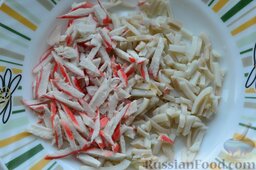 Салат с кальмарами и крабовыми палочками: Порезанные крабовые палочки высыпаем в тарелку к кальмарам.