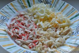Салат с кальмарами и крабовыми палочками: Высыпаем нарезанные яйца в тарелку к кальмарам и крабовым палочкам.