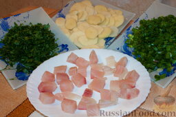 Пирог "Сумка шкипера": Филе рыбы вымыть, обсушить и нарезать небольшими кубиками.   Зеленый лук, укроп, петрушку вымыть и мелко нарезать.   Картофель вымыть, очистить и нарезать тонкими кружочками.