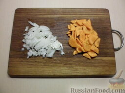 Суп с пельменями: Очистить лук и морковь. Лук нашинковать мелким кубиком, а морковь полукружиями.