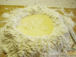 Торт "Наполеон": Сделать большую лунку в муке, перемешанной с кусочками маргарина. Вылить в лунку получившуюся смесь из стакана.