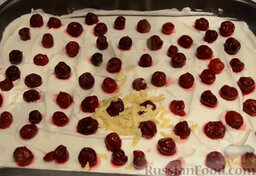 Песочный пирог с вишней: Выкладываем ягоды и натираем на крупной терке замороженное тесто.
