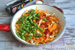 Теплый салат "Корейский колорит": Обжариваем смесь из курицы и морковки 5-7 минут. Затем добавляем стручковую фасоль и перец чили.