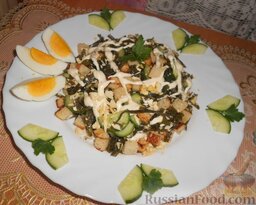 Салат с морской капустой и сухариками: Украсить салат майонезом, огурцами и яйцами.