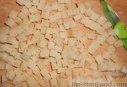 Салат с морской капустой и сухариками: Отрезать грубую корочку хлебных ломтиков и нарезать хлеб кубиками.