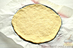 Пирог с квашеной капустой и зеленью: Минут через 40 можно начать формирование пирога с капустой. Делим тесто на две части. Раскатываем в пласты желаемой формы. Основание выкладываем на противень.