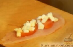 Куриные рулетики с помидорами и мягким сыром: Натираем кусочек куриной грудки солью, кладем на него 2-3 кусочка помидор и сыр.