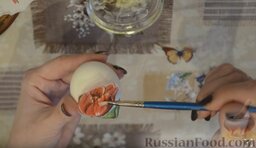 Декупаж яиц на Пасху: Обмакнуть кисточку в белок и смазывать сверху салфетку, приклеивая ее к яйцу.