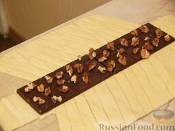 Рулет из слоеного теста, с шоколадом и орехами: На шоколад выкладываем кусочки орехов.
