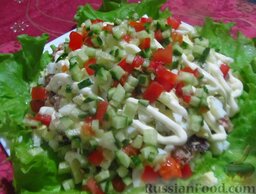 Слоеный салат с консервированной горбушей: Посыпьте слоеный салат с горбушей мелко рубленным помидором и огурчиком, это освежит композицию.