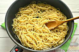 Спагетти с горошком и кукурузой: Готовые спагетти откидываем на дуршлаг, промываем под холодной водой. В этом случае спагетти не будут прилипать друг к другу.   Переправляем отварные спагетти на сковороду с разогретым растительным маслом (в данном рецепте используется подсолнечное). Поджариваем спагетти минут 5 на умеренном огне.