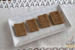 Канапе с лососем и маринованным имбирем: Нарезаем черный хлеб небольшими кусочками.