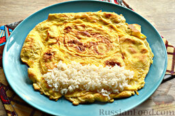 Роллы из яичных блинчиков с рисом и огурцом: На края блина выкладываем рис.