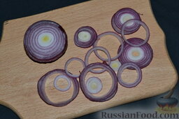 Салат "Русский" с сельдью: Красный лук очищаем, вымываем, разрезаем пополам. Одну половинку лука нарезаем кольцами, а вторую половинку луковицы оставляем для украшения салата.