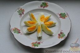 Салат "Русский" с сельдью: Отваренные яйца очищаем, нарезаем дольками.