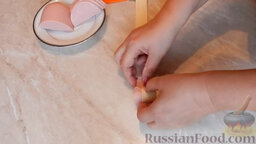 Булочки "Розочки" из слоеного теста, с колбасой: Свернуть колбасу вместе с тестом.