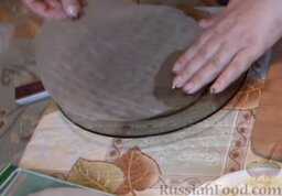 Спринг-роллы с копченой курицей: В отдельную миску налить немного воды и вымочить лист рисовой бумаги в течение 5 секунд. Затем стряхнуть лишнюю влагу.