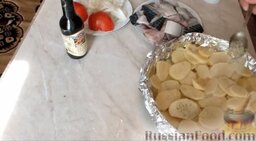 Скумбрия с картошкой, запеченная в духовке: Форму застелить фольгой. Выложить слой картофеля. Присолить его.