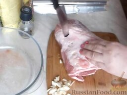 Свинина, запеченная в фольге: Сделать ножом глубокие надрезы и нашпиговать свинину чесноком.