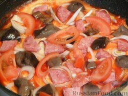 Быстрая пицца на сковороде: Выкладываем ветчину или копченую колбасу, нарезанную небольшими кубиками. Затем выкладываем помидоры, нарезанные тонкими пластинками. Помидоры посолить и поперчить.