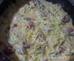 Макароны с сосисками, запеченные в сливках, с сыром: Засыпьте макароны сыром, поставьте сковороду в разогретую до 180 градусов духовку.