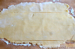 Песочные трубочки с ревенем и корицей: С помощью кухонной скалки раскатываем тесто в тонкий пласт, нарезаем полосками (шириной по 7 см).  Выкладываем ревень, заворачиваем, отрезаем лишний кусочек теста.