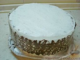 Торт с творожным кремом и киви, с шоколадным "бантом": По окружности торта приложить поочередно полоски с ажурным рисунком, немного их придавить.